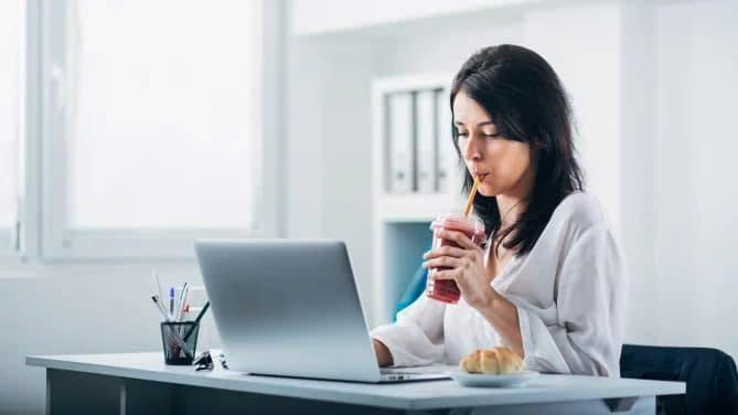 Người làm việc văn phòng thưởng thức nước ép lựu trong giờ nghỉ.