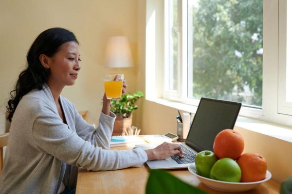 Người làm việc văn phòng thưởng thức nước ép táo trong giờ nghỉ.
